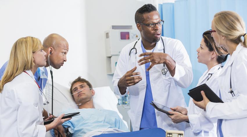 Doctor giving instructions to medical students while seeing a patient