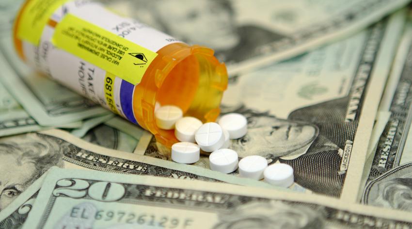 Prescription pills spilling out of the bottle on a twenty dollar bills