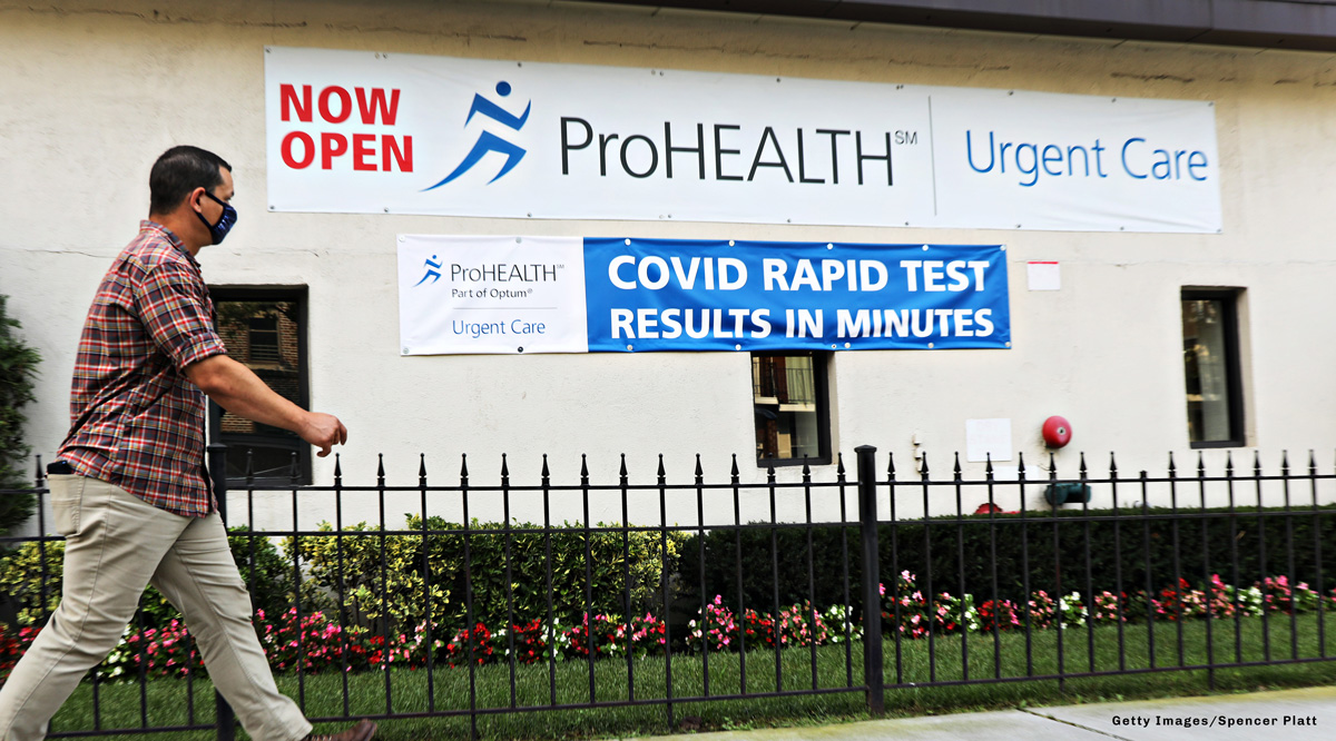 A man walking past a COVID Rapid Test sign