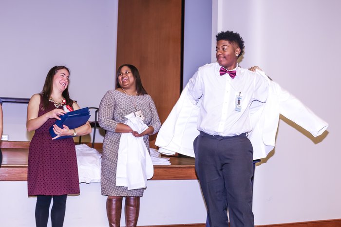 a student receives a white coat at the end of the program
