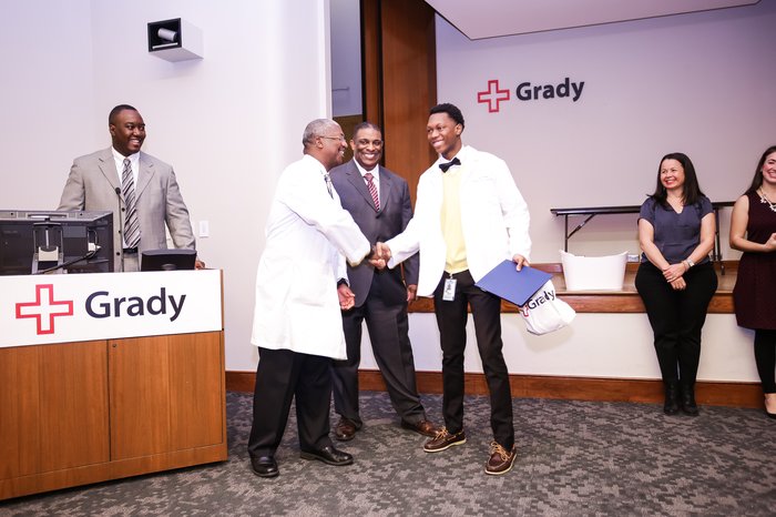 Drs. Omar Danner, Derrick Beech, and Ed Childs from Morehouse School of Medicine congratulating a student who completed the program.