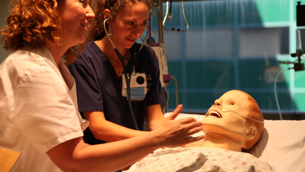 two medical students with a patient manikin