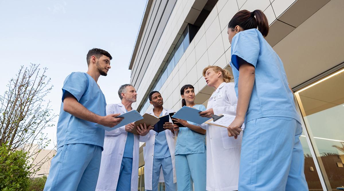 A group doctors stands outside while talking