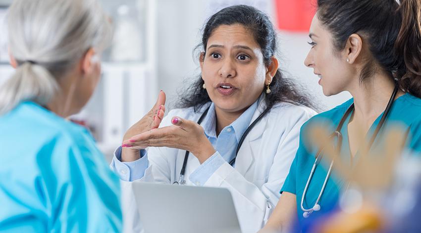 A female doctor talking to colleagues in an office