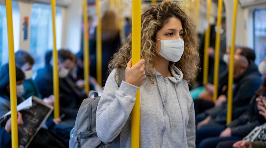 Woman riding on the metro wearing a facemask to avoid an infectious disease