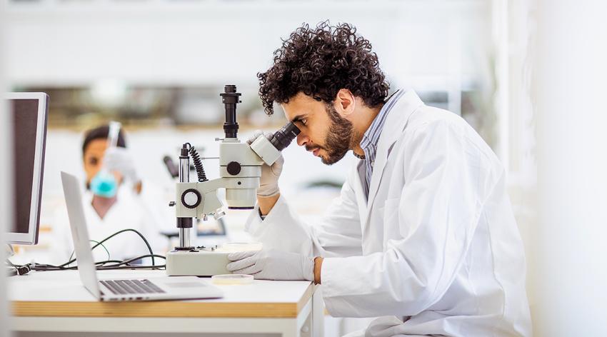 Scientist working in the laboratory with a microscope